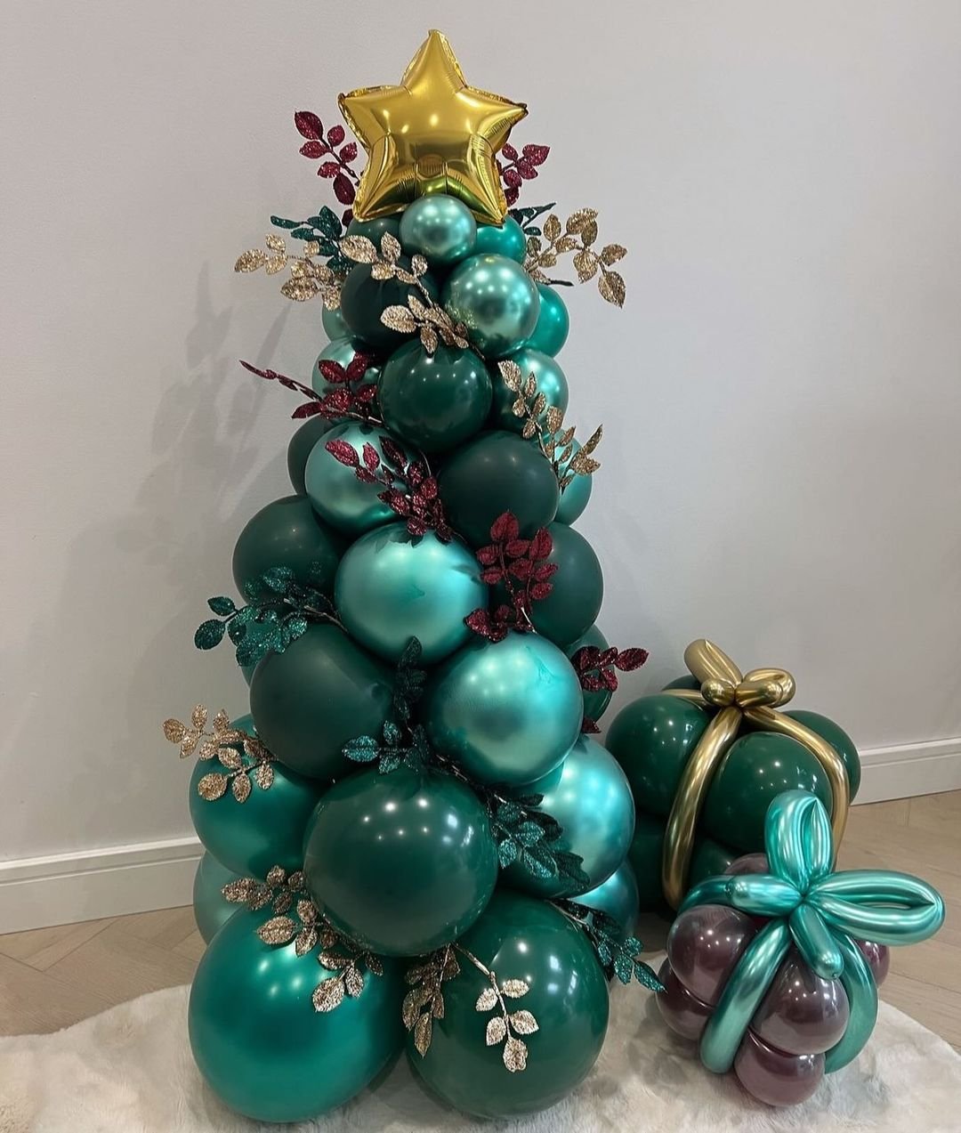 A festive green Christmas tree adorned with gold and green balloons, creating a vibrant and joyful Balloon Tree.