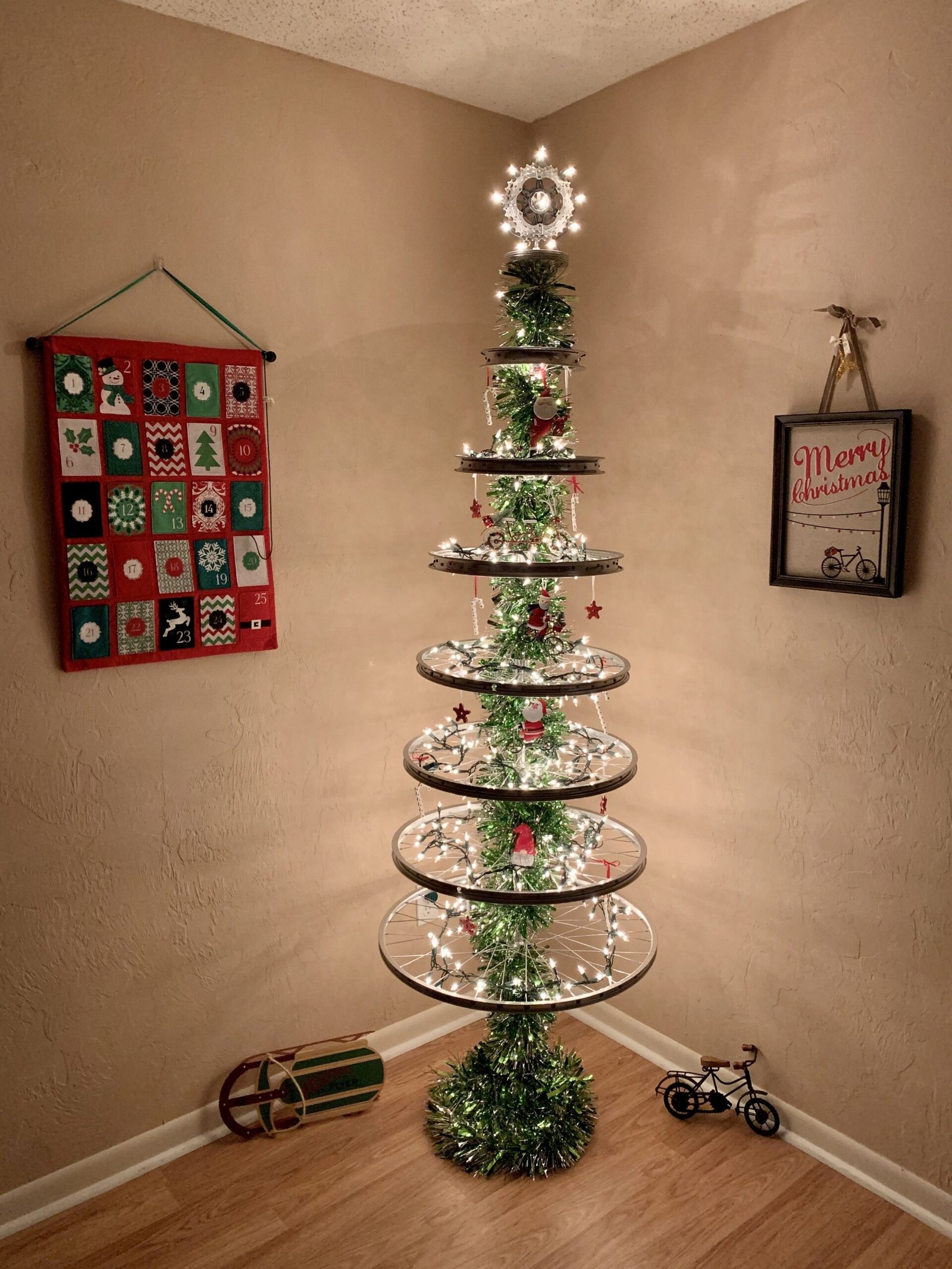 A Christmas tree named "Bicycle Wheel Tree" glowing with lights, adding a festive touch to a room. 
