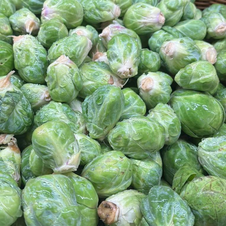 A basket filled with Brussels sprouts, forming a large pile.