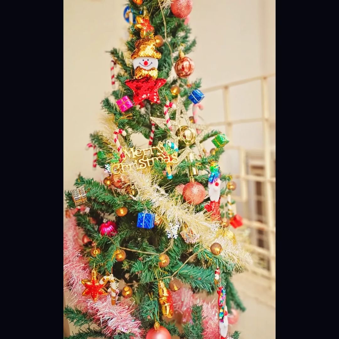 Colorful Christmas tree adorned with festive ornaments and decorations.