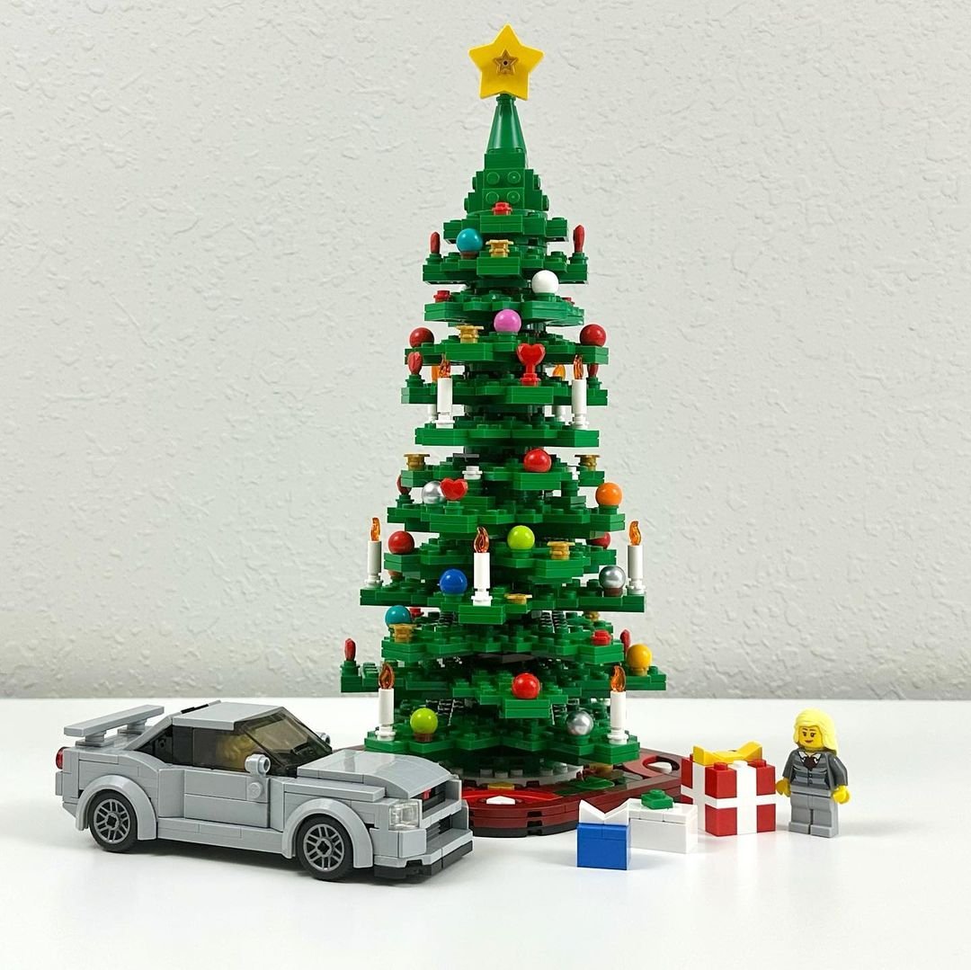 A festive Lego Christmas tree adorned with a toy car and colorful presents.