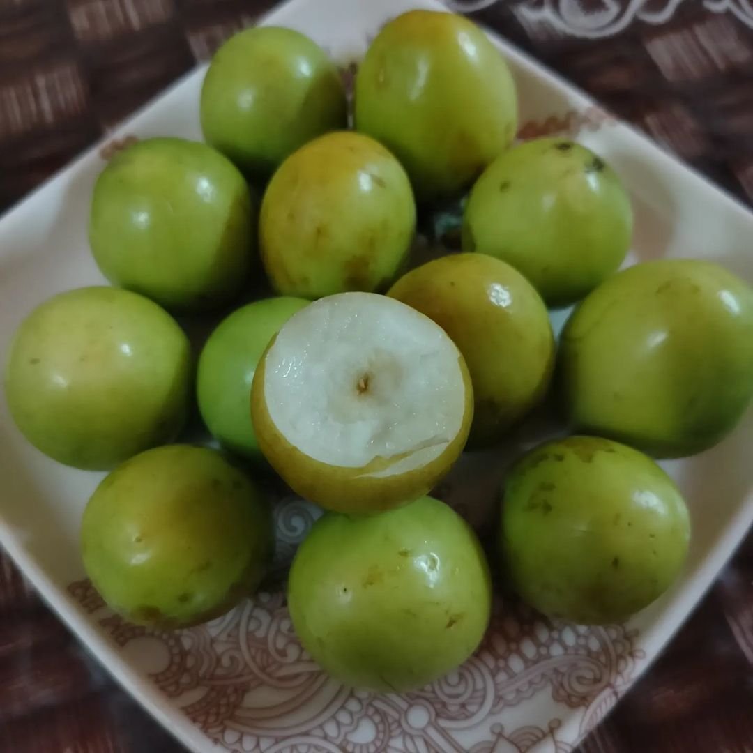 A plate with green fruits on it, including Monkey Apples.

