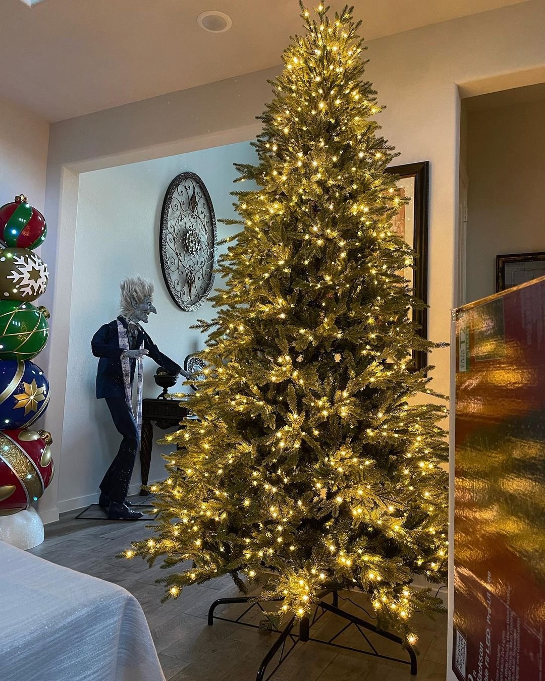 A Noble Fir Christmas tree in a living room, with a man standing in the background.
