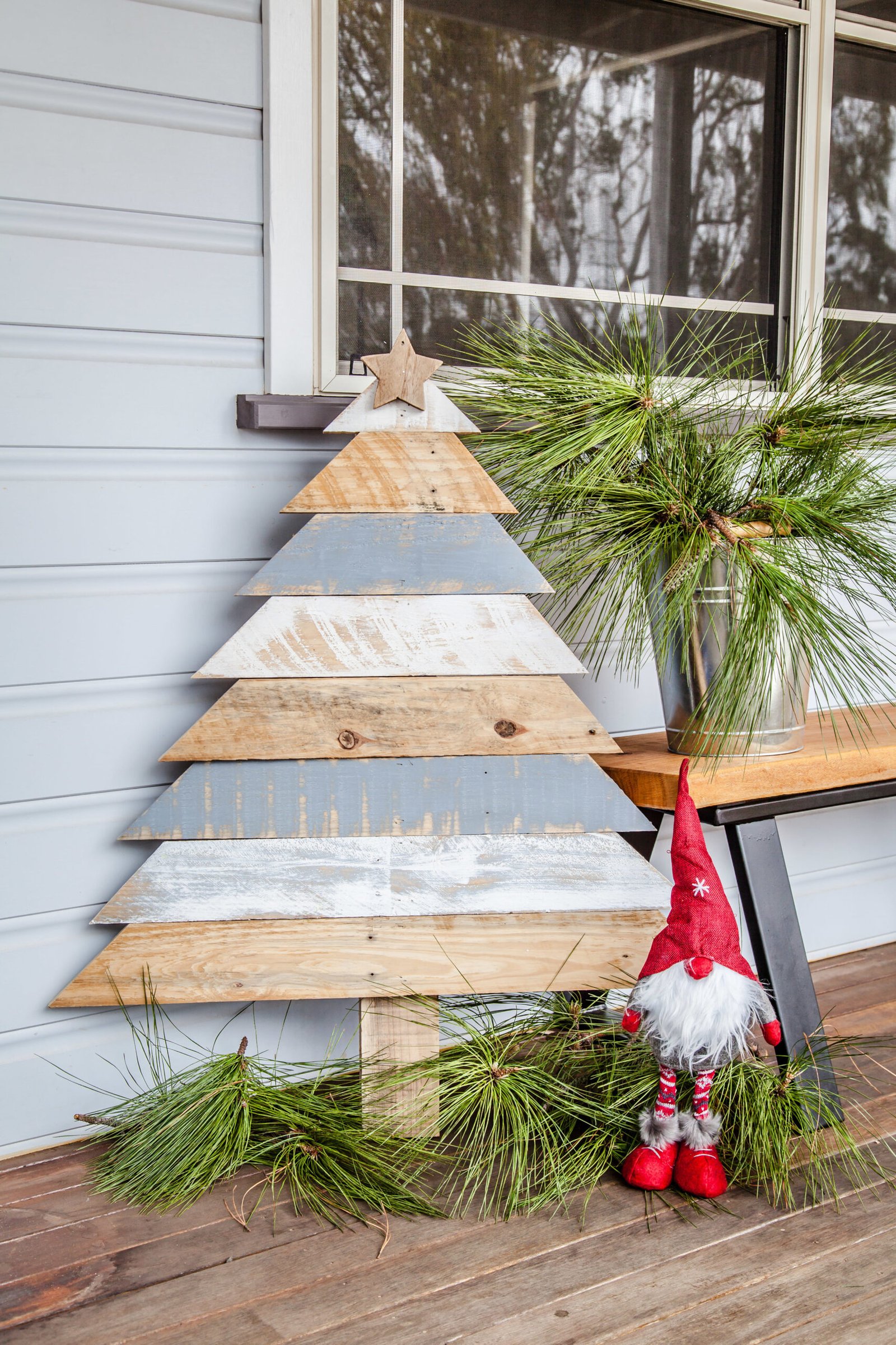 A festive Pallet Tree adorned with pine cones and a gnome, bringing the holiday spirit to life.