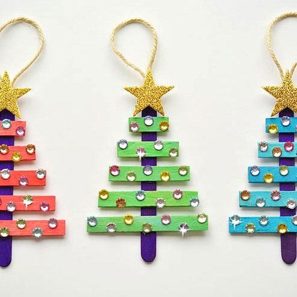 Three colorful Christmas tree ornaments on sticks, arranged in the shape of a Popsicle Stick Tree.
