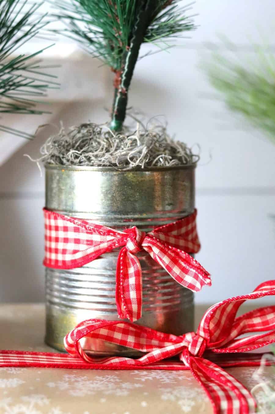 A festive tin can adorned with a miniature Christmas tree, bringing holiday cheer in a compact display.