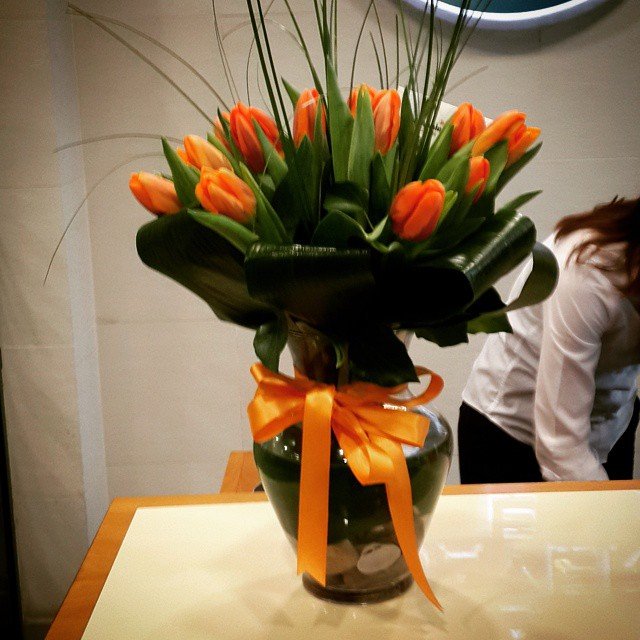 A vase containing bright orange tulips.