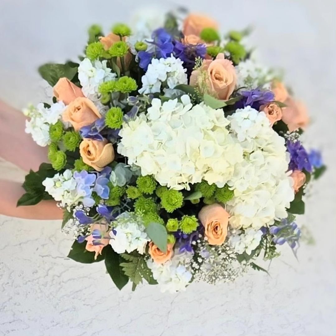 A hand-tied bouquet featuring an elegant arrangement of white, blue, and purple flowers, showcasing natural beauty.