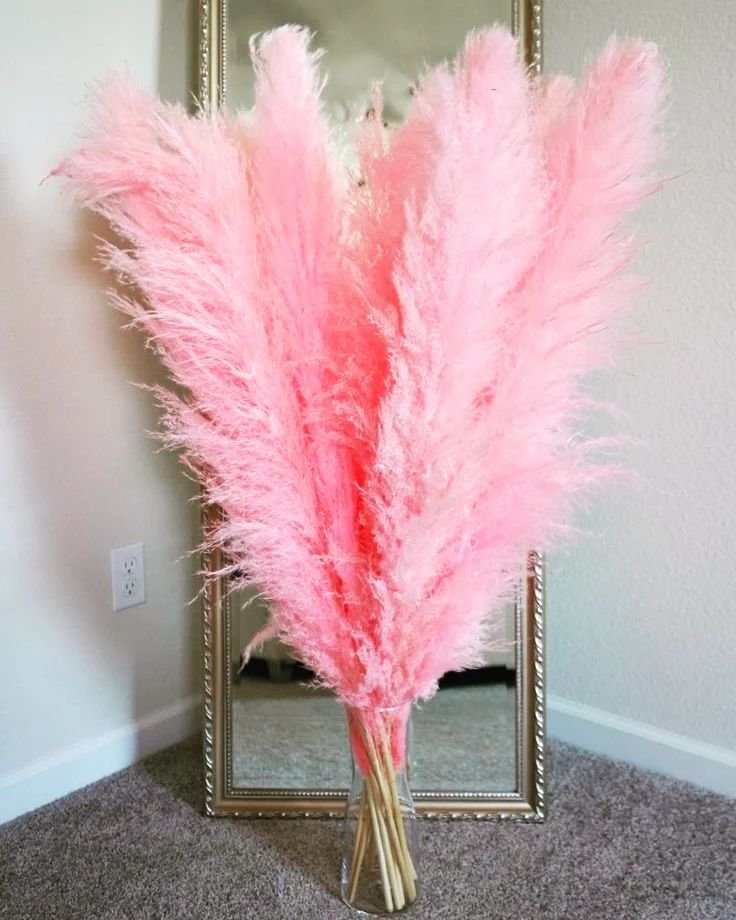 A delicate bouquet featuring pink ostrich feathers and pink pampas grass, creating a soft and elegant floral arrangement.