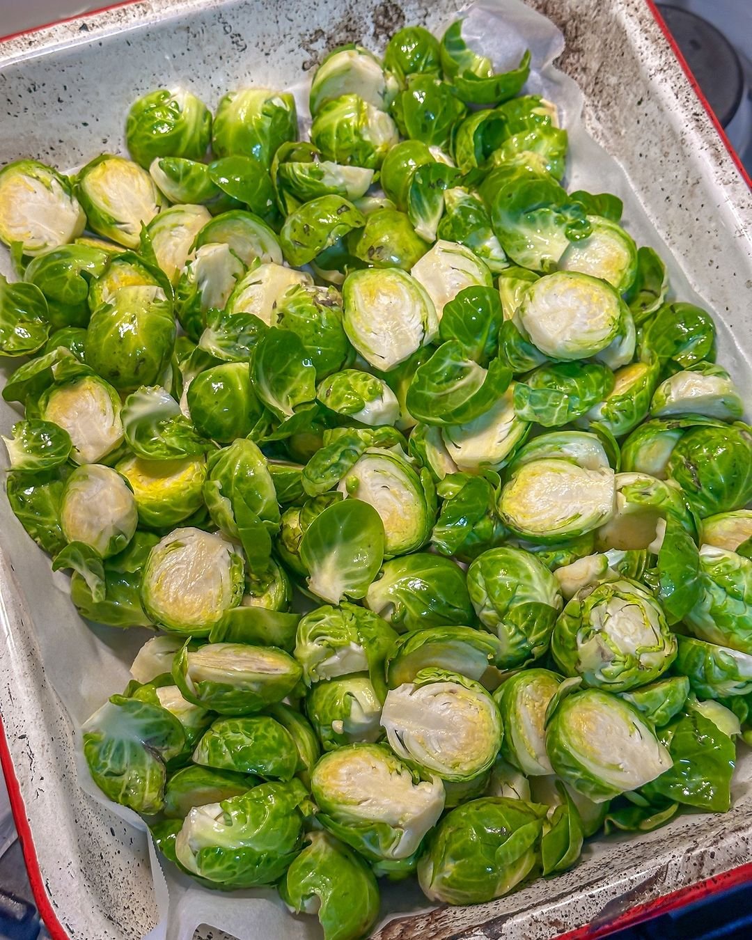 A tray of brussels sprouts on a stove.