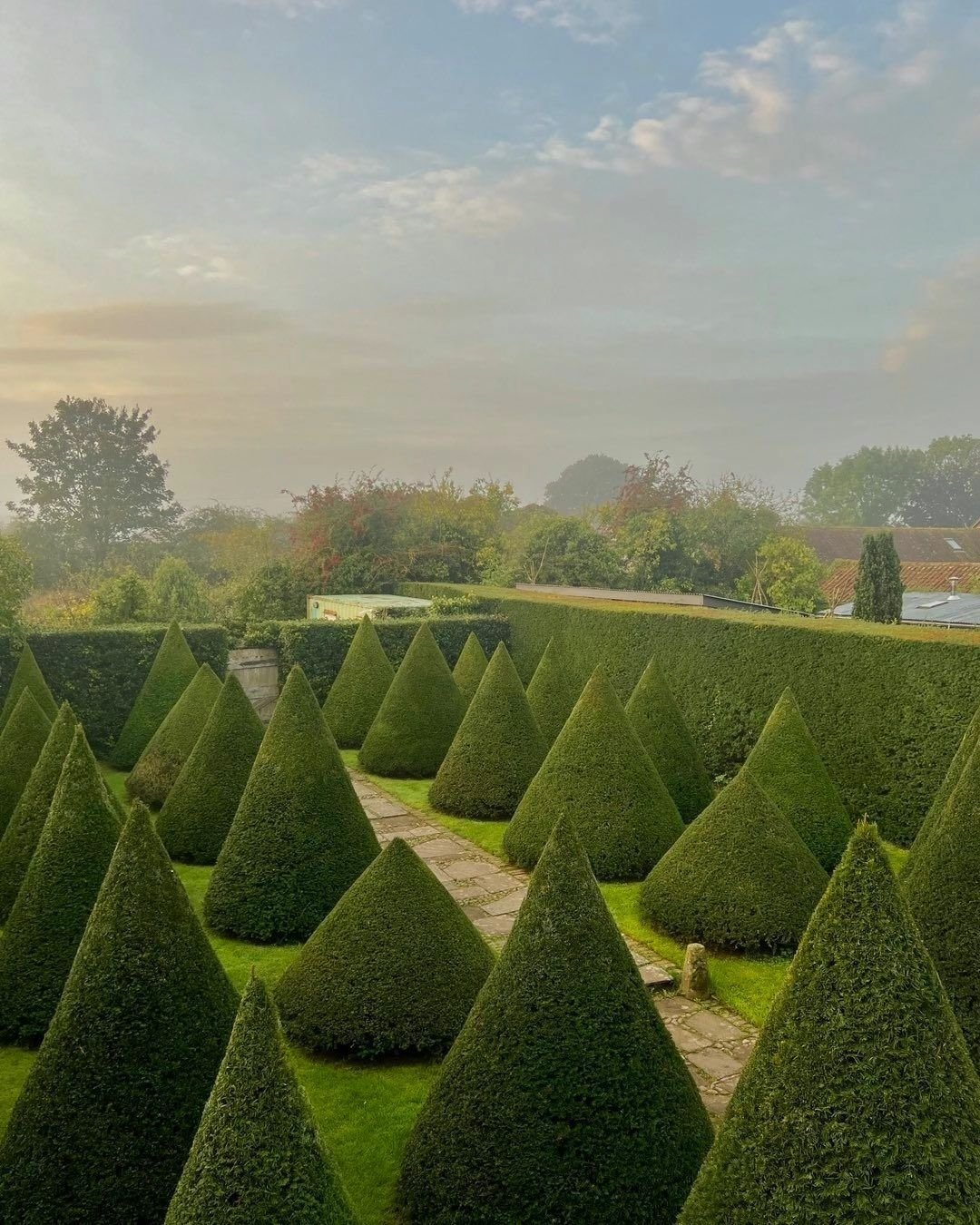 A beautifully manicured topiary garden featuring intricate yew shapes at the Chateau de la Belle-Etre.